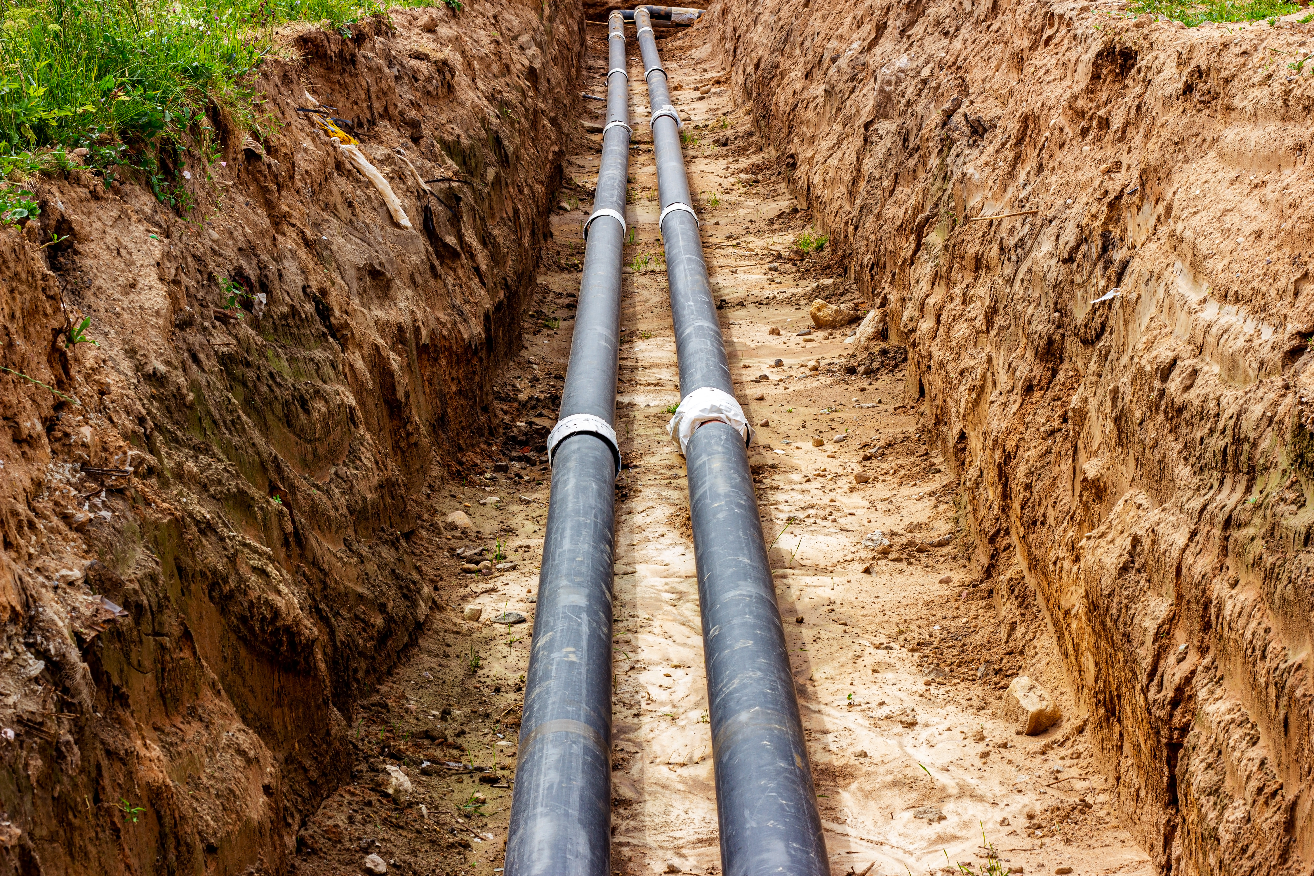 Hydro excavation slot trenching for pipe and conduit installation